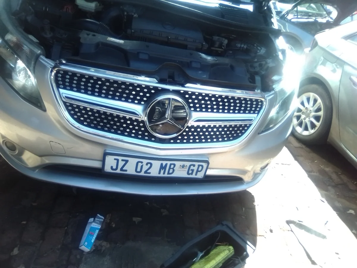 Mobile mechanic working on car engine